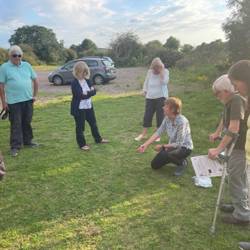Woman kneeling and talking to others stood around her
